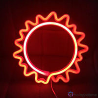 Néon LED soleil bicolore rouge et orange posé contre mur bordeaux, cercle avec rayons ondulés lumineux, décoration murale
